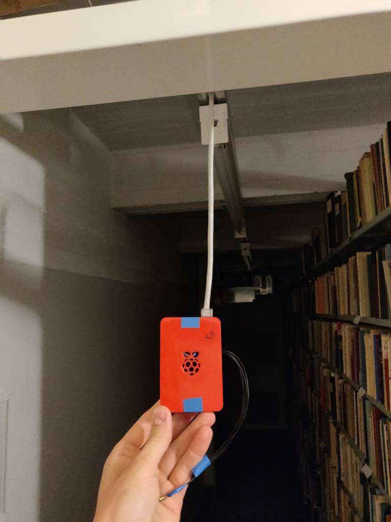 Red raspberry pi on hand. This device has been used to measure the conditions in the library of the university of Turku