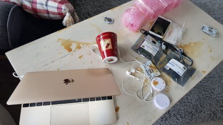 A messy table with computers and Ruuvi Tags
