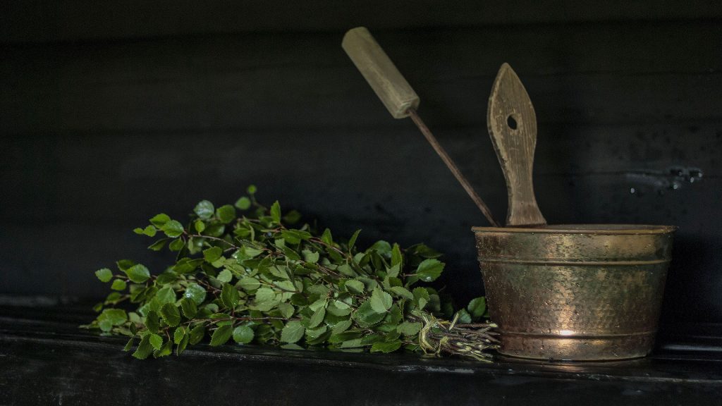 Birch bath broom and a bucket in a sauna