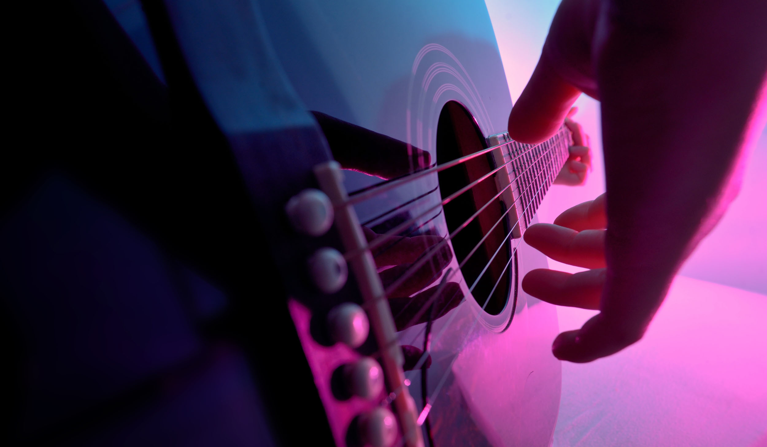 Acoustic guitar played by a girl in colorful lights
